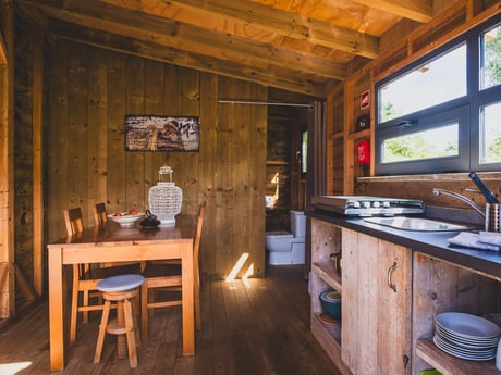 The wooden cabin offers all the comforts of home with a cozy, fully equipped kitchen and a modern bathroom. Thoughtfully designed with natural touches, both spaces combine practicality and charm, making your stay as comfortable as it is relaxing.